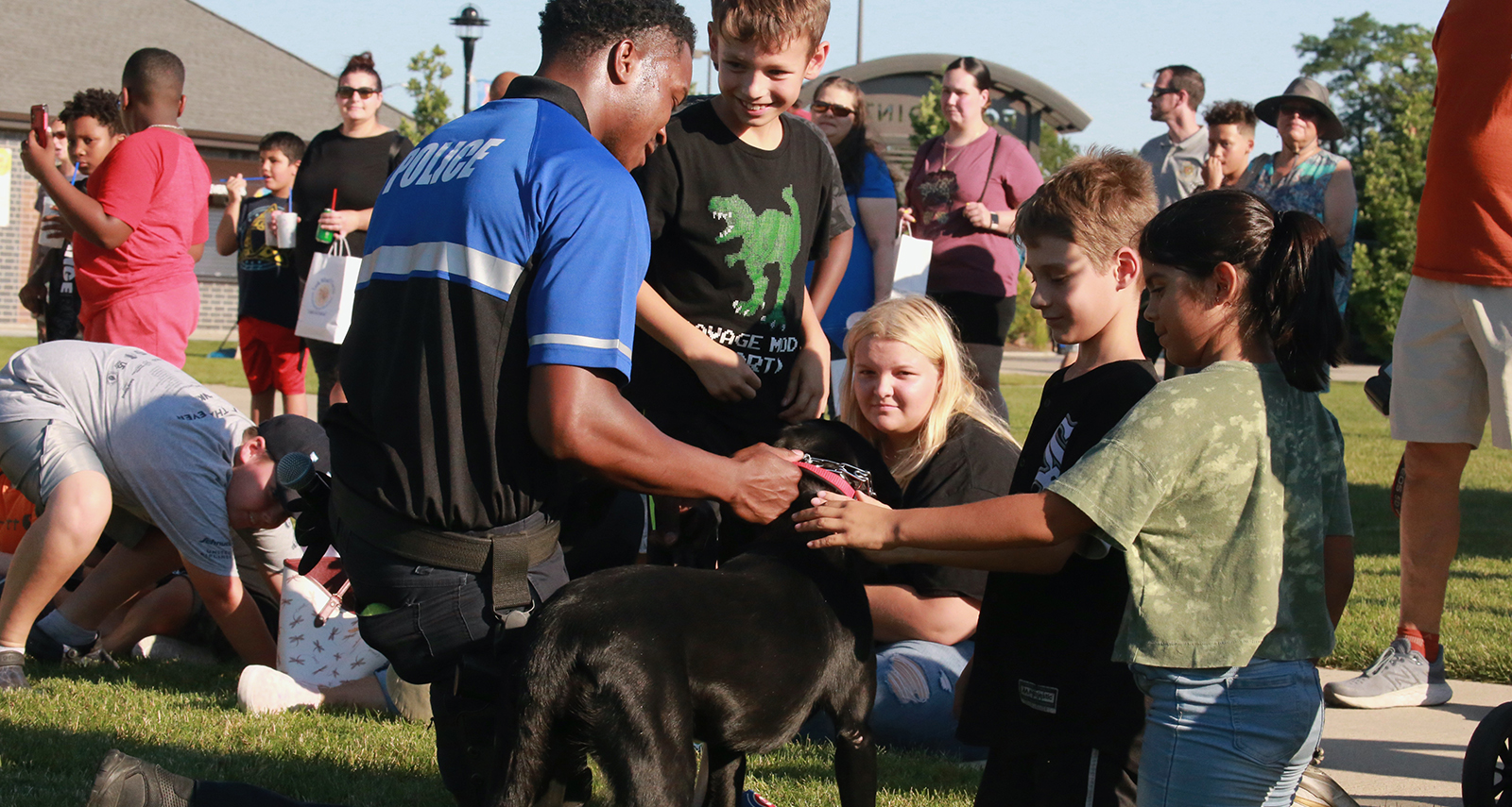Lansing National Night Out - police officer with a dog that kids are petting - 