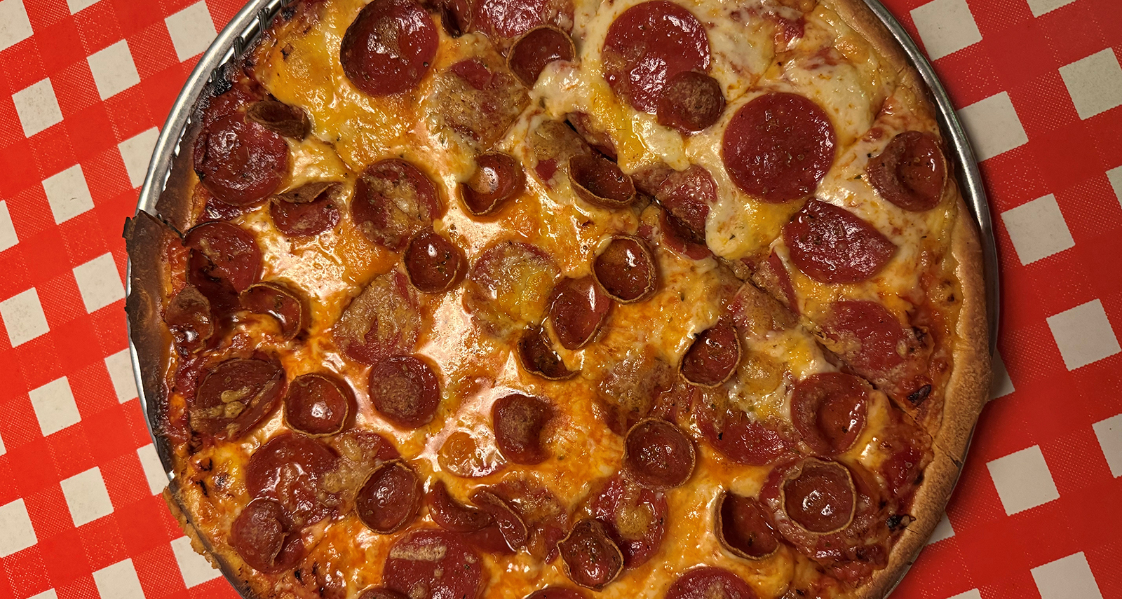 round pizza with crispy pepperoni on top with cheese on a red checkered background - Pope Leo XIV Pizza